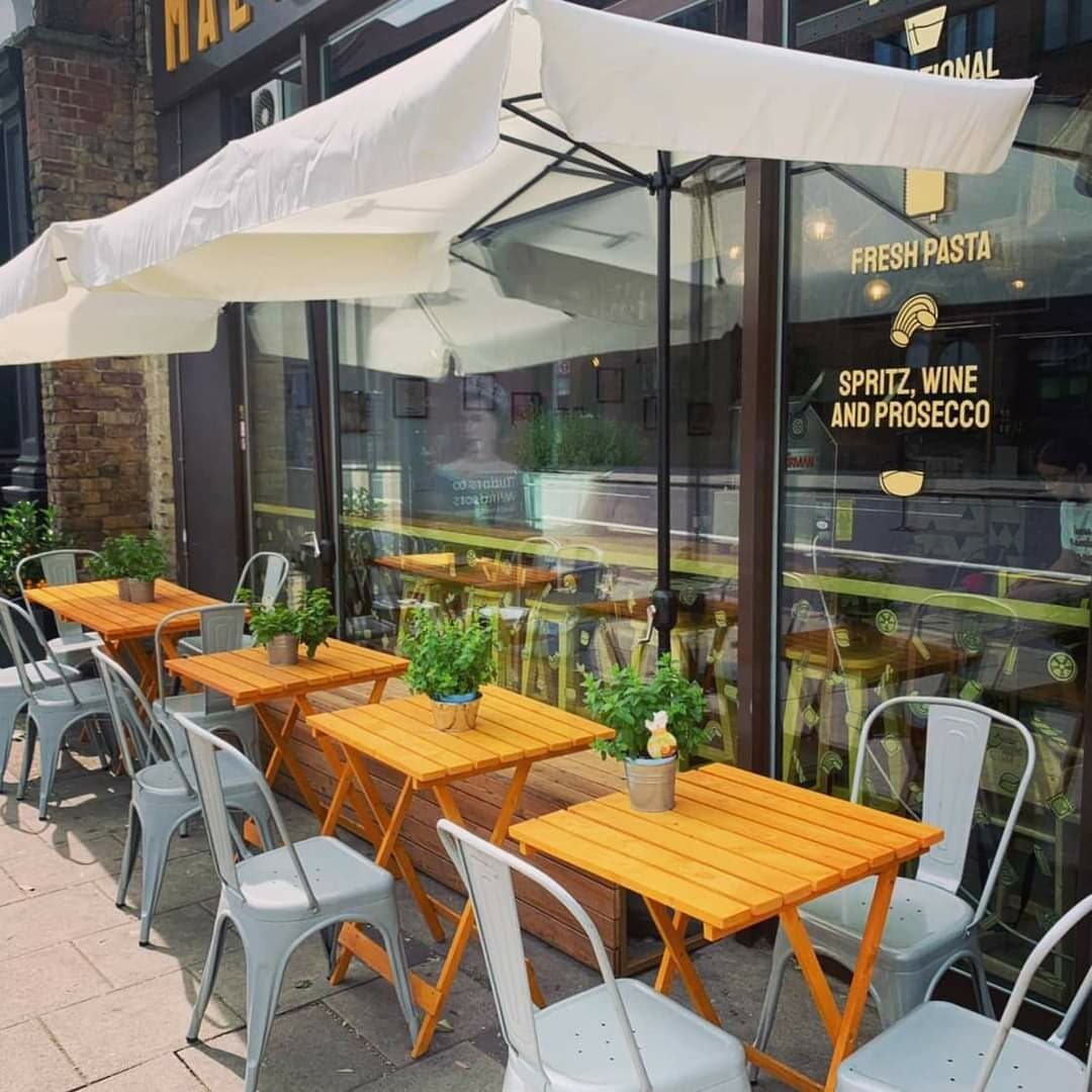 The Maestri della Pasta storefront on Borough High Street in London, with outdoor tables under white parasols.